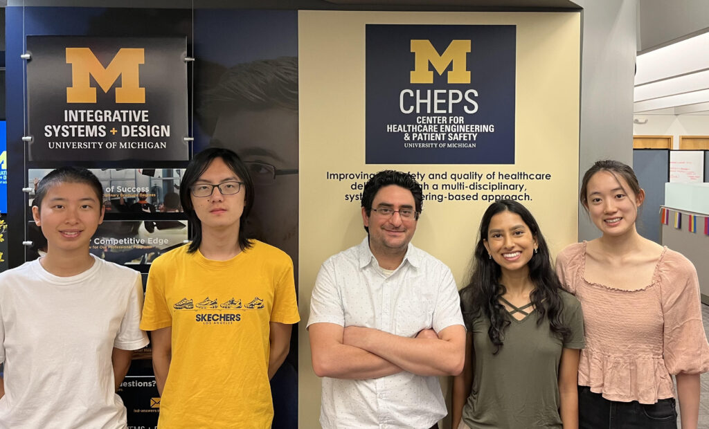 Four students on the MERCI team and CHEPS Software Manager Hooman Niktafar smile in front of a CHEPS sign.