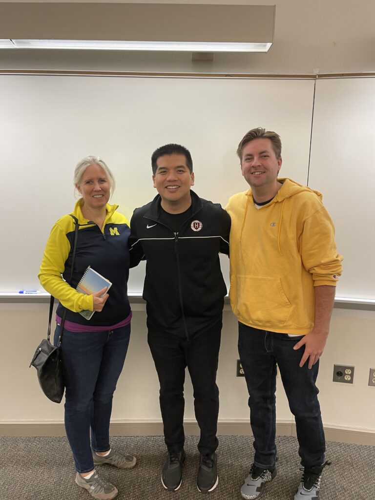 Ryan Chen standing in front of an empty whiteboard and smiling with CHEPS Faculty Director Amy Cohn and CHEPS Research Manager Billy Pozehl.