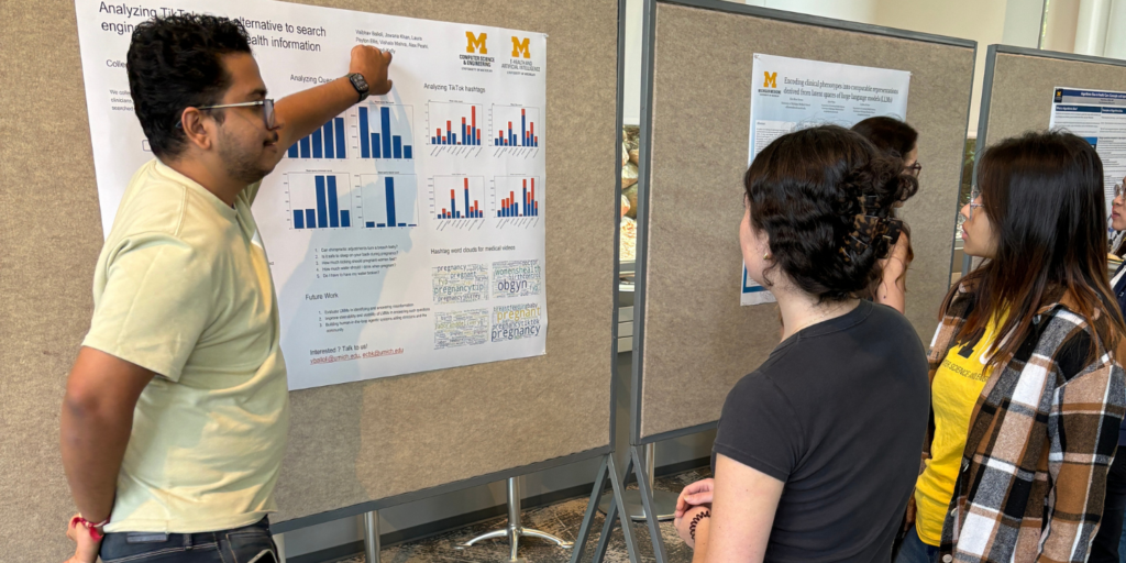 CHEPS student, Amber Campbell, views poster on the risks of utilizing Tik Tok as a medical search engine. A presenter speaks to her while pointing at the poster.