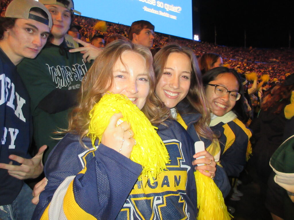 Jill, Goretti, and Nikki cheering the Wolverines to victory against Michigan State.